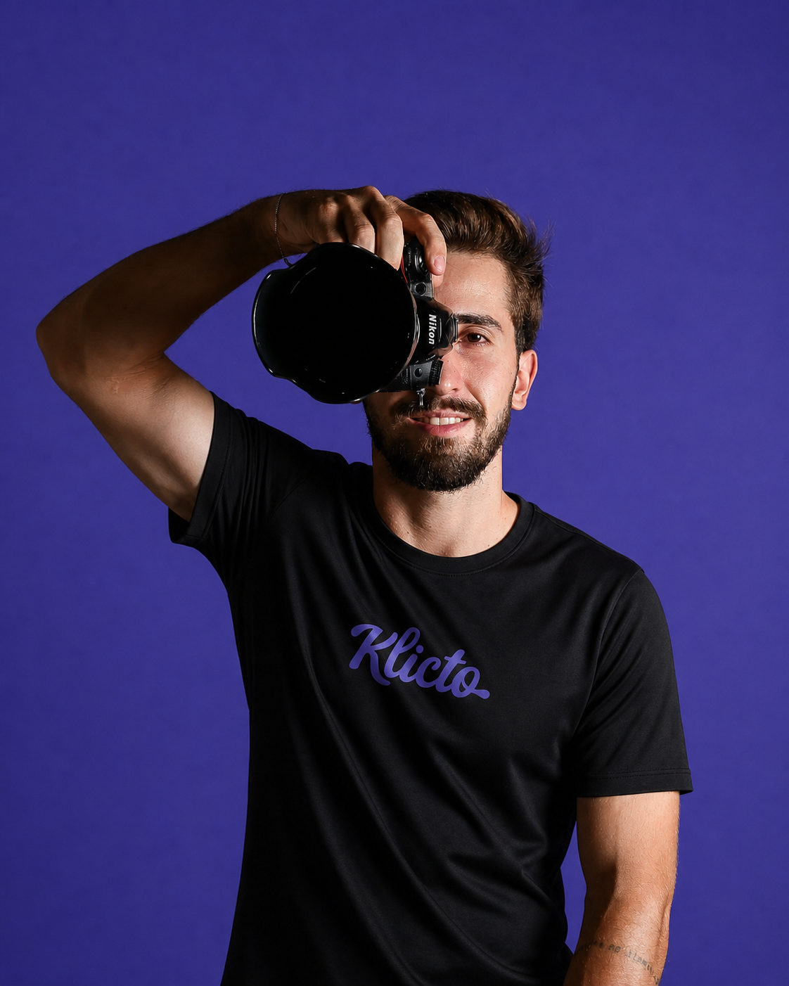 Fotógrafo segurando uma câmera com a marca Klicto